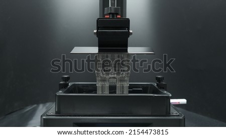 SLA 3D Printer lifting 3d printing complex object using clear uv resin Royalty-Free Stock Photo #2154473815