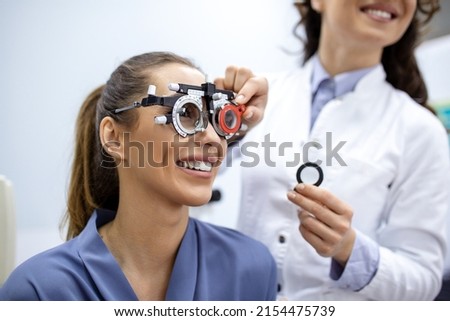 Ophthalmologist examining woman with optometrist trial frame. female patient to check vision in ophthalmological clinic. Royalty-Free Stock Photo #2154475739