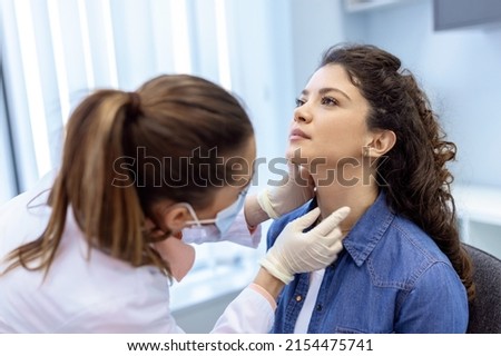 medicine, healthcare and medical exam concept - doctor or nurse checking patient's tonsils at hospital. Endocrinologist examining throat of young woman in clinic Royalty-Free Stock Photo #2154475741