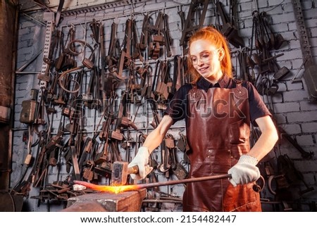 redhead ginger woman blacksmith portrait in workshop Royalty-Free Stock Photo #2154482447