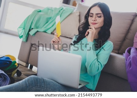 Photo of young girl look laptop think dream vacation hold documents choise place for vacation indoors