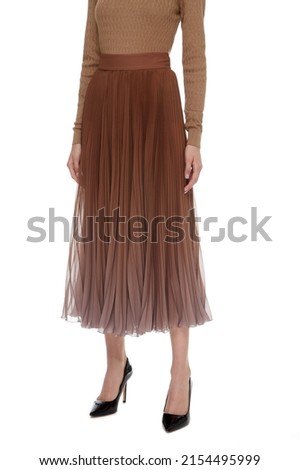 Brown Beige women's luxury evening Maxi Chiffon Pleated Skirt on model isolated on white background, woman wearing Long Glossy Skirt, autumn spring outfit, top front view. Long legs in hight heels Royalty-Free Stock Photo #2154495999