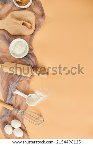 Bakery  or cooking frame, ingredients, kitchen items for pastry on pastel orange background. Top view, copy space.