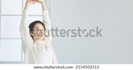 Middle aged Asian woman relaxing in the room.