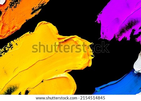 Multicolored smudges of oil paint isolated on black background.