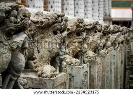 Guardian dragon statues at Wat Arun temple, Bngkok, Thailand. Stone statues at Wat Arun. Thailand temples.