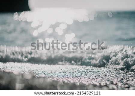 Abstract nature summer ocean sunset sea background. Small waves on water surface in motion blur with bokeh lights from sunrise. Holiday, vacation and recreational background concept.