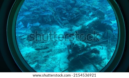 Aruba -2022: View from viewing portals on Atlantis VI Submarine. Canadian passenger submarine company. Interior of the tourist submarine Atlantis whilst submerged. Sunken ship makes coral reef. Royalty-Free Stock Photo #2154536921