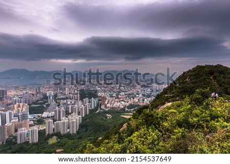 The view of the Kowloon walled city from Lion Rock hill under a stormy cloudy sky in Hong Kong, China
