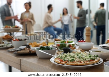 Brunch table setting with different delicious food	and blurred view of people on background