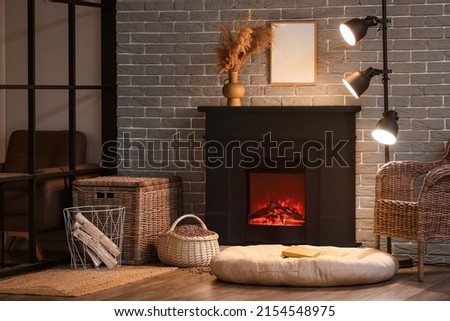 Interior of modern living room with black fireplace near brick wall
