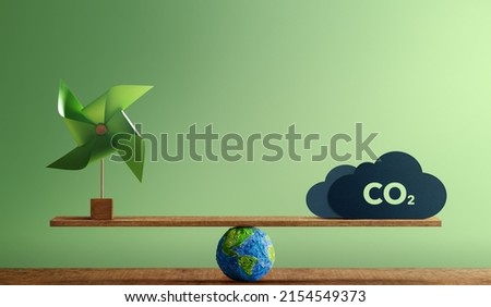 Carbon Neutral and ESG Concepts. Carbon Emission, Clean Energy. Globe Balancing between a Wind Turbine and CO2. Sustainable Resources, Environmental Care. Making a Wind Energy Royalty-Free Stock Photo #2154549373