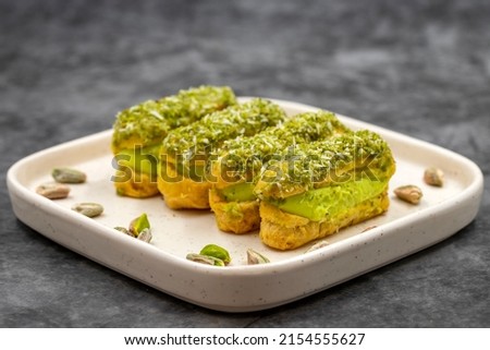 Pistachio eclair cake. Eclair cake with pistachio filling on a dark background. close up Royalty-Free Stock Photo #2154555627