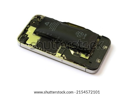 Swollen lithium ion polymer battery inside a mobile phone on isolated white background