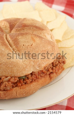 hamburger (sloppy joe) in sauce inside a bun and chips