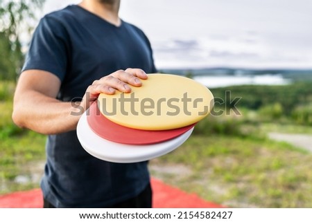 Disc golf player with equipment in park course. Man playing discgolf. Outdoor sport tournament. Summer landscape in Finland.