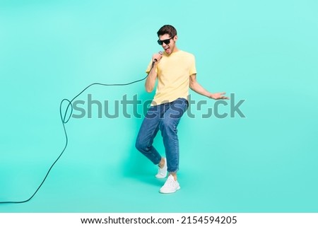 Full length photo of funny brunet young guy sing wear glasses t-shirt jeans footwear isolated on turquoise background Royalty-Free Stock Photo #2154594205