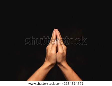 praying hands with faith in religion and belief in God on dark background.