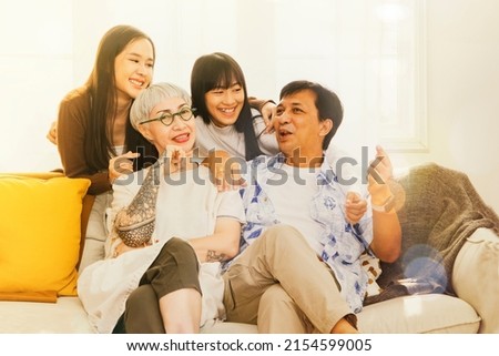 Perfect happy family : Portrait large Asian parent and healthy sister sitting on the sofa relaxing on the sofa. Take pictures at home good mood Spend time together having fun and having fun.
