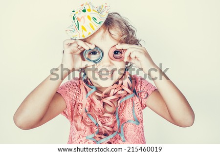 Funny little girl with streamers Royalty-Free Stock Photo #215460019