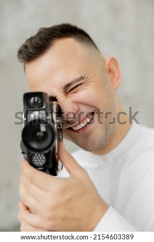 Photographer in white shirt holding camera
