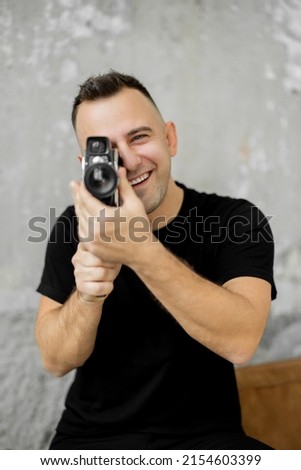 Photographer in black shirt holding camera