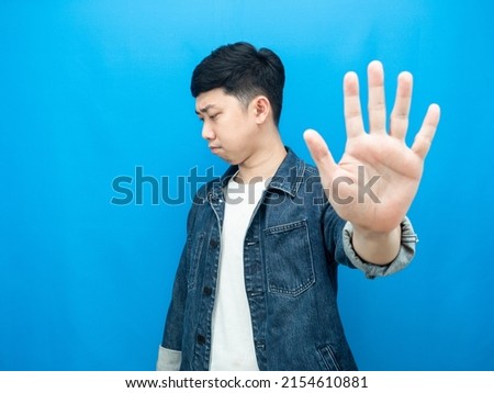 Man jean shirt show hand stop turn away face serious emotion blue background Royalty-Free Stock Photo #2154610881