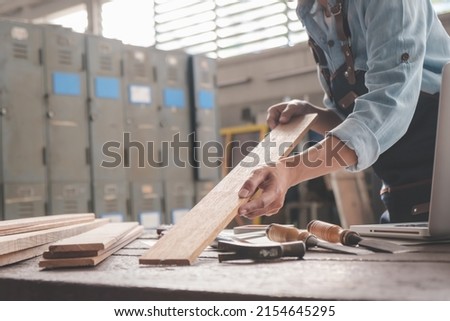 Carpenter working with equipment on wooden table in carpentry shop. woman works in a carpentry shop. Royalty-Free Stock Photo #2154645295