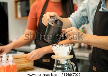 Barista pouring boiling water from kettle to drip coffee maker at the bar of the modern cafe,Entrepreneur business concept banner.