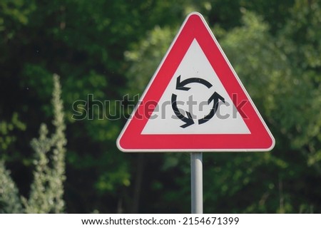 Close-up shot of a roundabout yield traffic sign attached to a metal pole 
