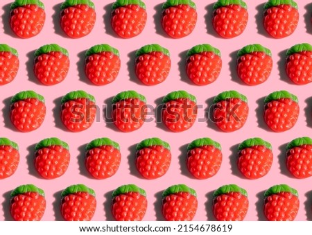 Top view of tasty gummy candies in shape of strawberry on pink