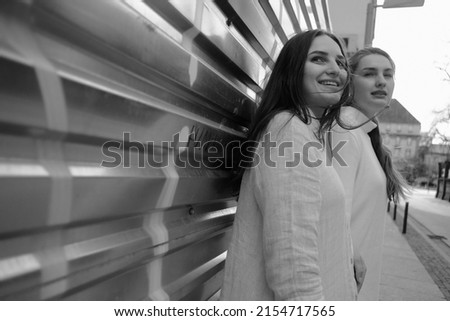 Black and white portrait of two girls. Girls in white dresses walking in the street