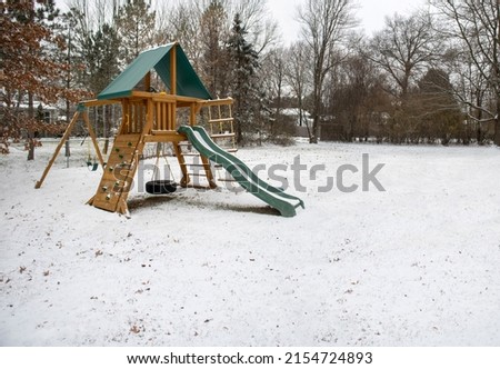 Wooden Swing Set Kids Slide Outdoor Backyard Playground Playset Clubhouse, rock climbing wall, swings with tire swing, an access ladder on a snow winters day