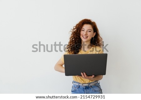 Portrait of young woman holding laptop on a white background