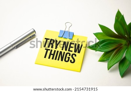 Text sign showing TRY NEW THINGS and pen