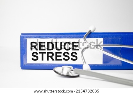 REDUCE STRESS - business concept, message on the sticker on the folder
