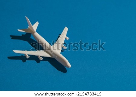 Side view of a miniature airplane on blue background, Travel or traffic image