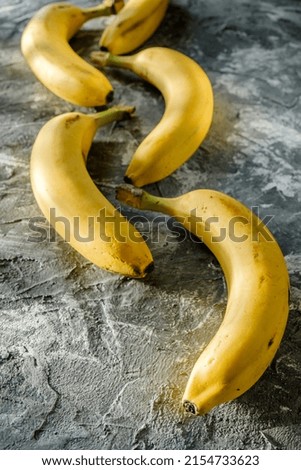 creative banana photo for advertising, fresh beautiful bananas on a gray background, delicious fruits