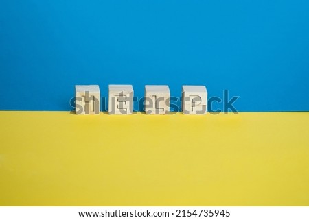 Wooden cubes arranged horizontally on blue and yellow background. Conceptual, symbolic image of the colors of the flag of Ukraine with the keyword help.