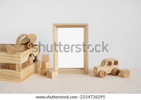 Baby photo frame mockup with wooden toys and cubes.
