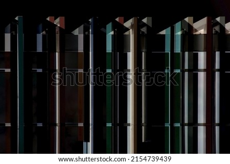Double exposure photo of framed windows. Structural glazing. Office building with glass wall. Modern architecture viewed in perspective from below. Material construction with steel and glass pattern.