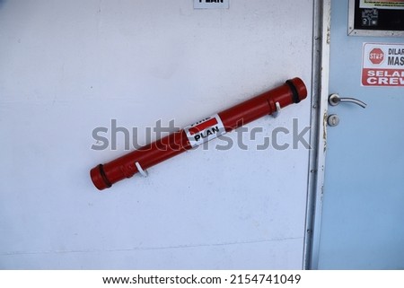 a locked fire safety plan box on a red wall for information for fire fighters on ship or dock