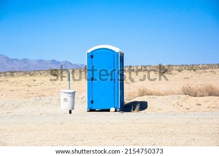 Porta Potty in Middle of Nowhere next to Trash Can Royalty-Free Stock Photo #2154750373