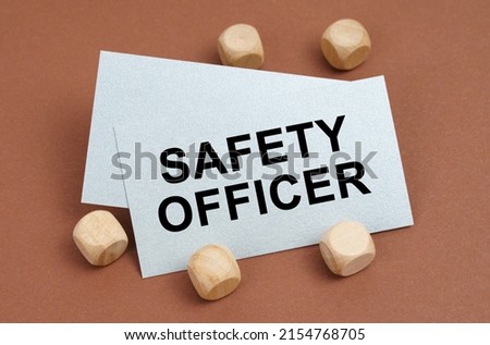 The concept of industrial safety. On a brown surface, wooden cubes and a business card with the inscription - Safety Officer
