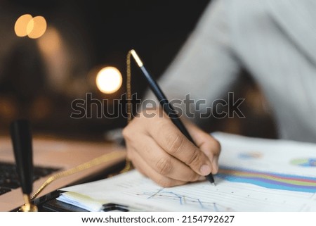 professional businessman making a business sign by a pen on deal contract document agreement paper, closeup on hand and paperwork signature form on corporate office table desk