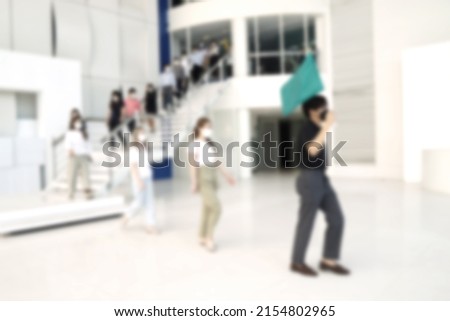 Blurred of evacuation an office building. People exit the building on exit door.