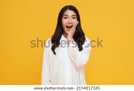 Amazed young Asian teen woman looking at camera on yellow background. Royalty-Free Stock Photo #2154817185