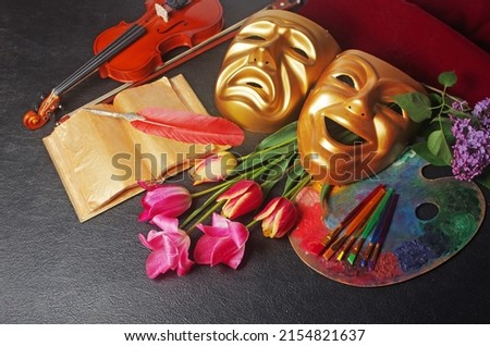 Attributes of the arts. Music, literature, painting, theater. Violin, book and fountain pen, art palette, brushes, theatrical masks and a bouquet of tulips. On a black background.
 Royalty-Free Stock Photo #2154821637