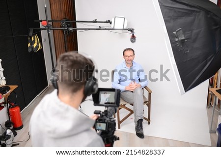 young man video camera operator making interview in professionnal broadcast tv movie studio film production Royalty-Free Stock Photo #2154828337