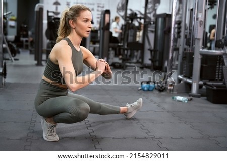 Dynamic stretching of young caucasian woman on a gym Royalty-Free Stock Photo #2154829011